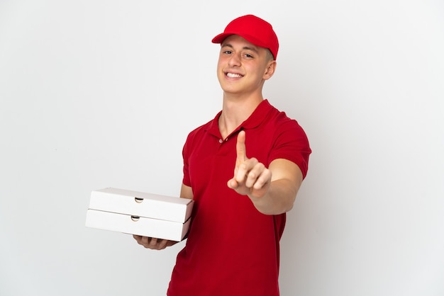 Livreur de pizza avec uniforme de travail ramasser des boîtes de pizza isolé sur fond blanc montrant et en soulevant un doigt