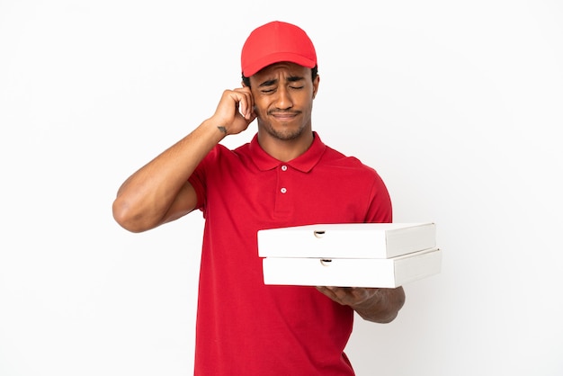 Livreur de pizzas afro-américaines ramassant des boîtes de pizza sur un mur blanc isolé frustré et couvrant les oreilles