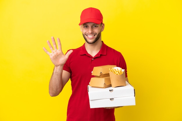 Livreur de pizzas ramasser des boîtes de pizza et des hamburgers sur fond isolé comptant cinq avec les doigts