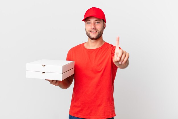 Livreur de pizzas souriant fièrement et avec confiance faisant le numéro un
