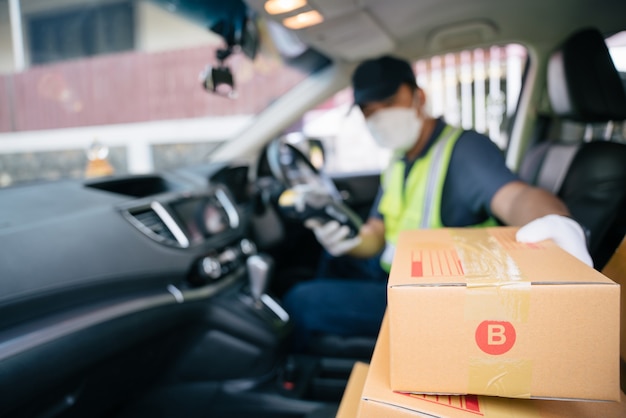 Un livreur récupère une boîte dans la voiture d'un ami pour la livrer à un client, Select focus a box.