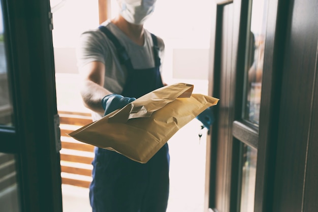 Le livreur remettant le colis au client à son domicile