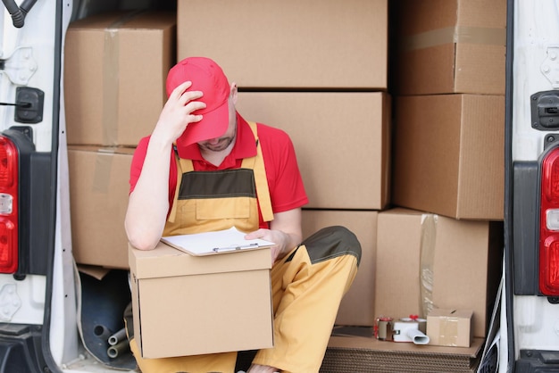 Le livreur s'assoit dans la camionnette avec le reçu de livraison et attend le client