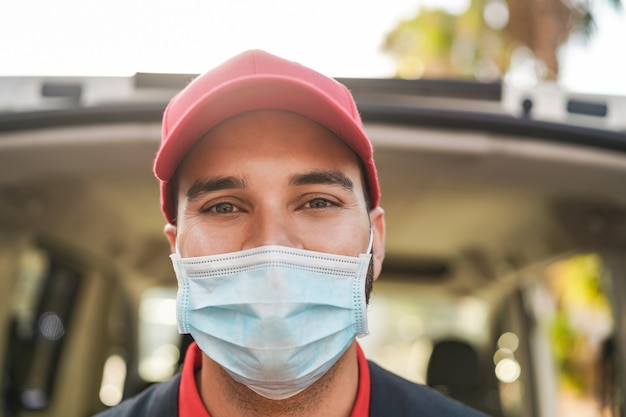 Livreur souriant à la caméra tout en portant un masque de sécurité