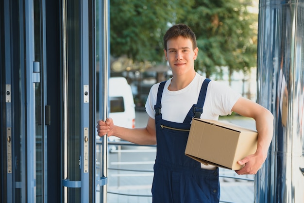 Livreur souriant tenant une boîte en papier