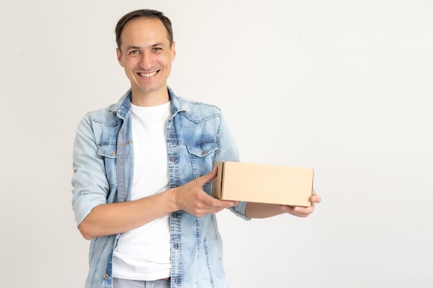 livreur souriant tenant un gros colis isolé sur blanc