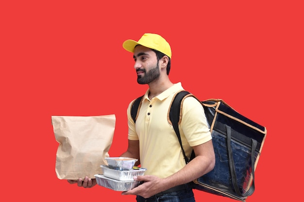 livreur en t-shirt jaune transportant un sac en papier sac à dos avec des plats à emporter modèle pakistanais indien