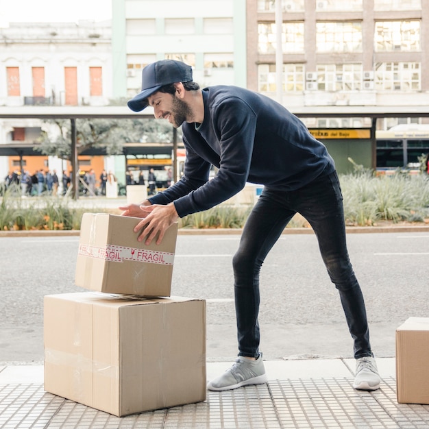 Photo livreur transportant des colis près de la rue