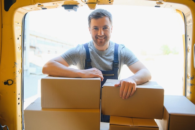 Livreurs déchargeant des cartons de déménagement d'une voiture