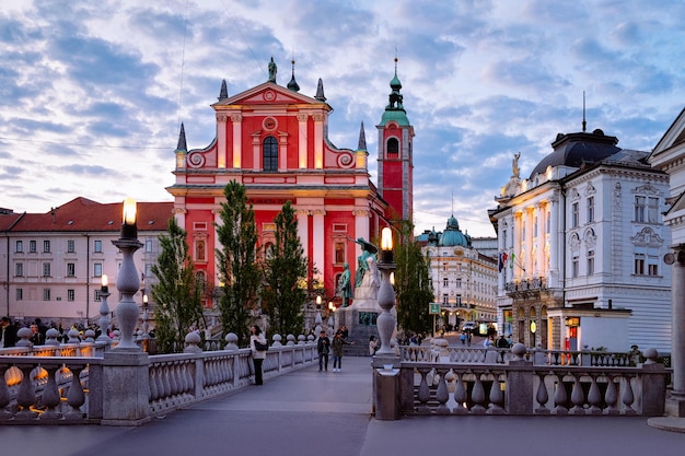 Ljubljana, Slovénie - 27 avril 2018 : Les gens de l'église franciscaine de l'Annonciation et du Triple Pont dans le centre historique de Ljubljana, Slovénie. Tard dans la soirée