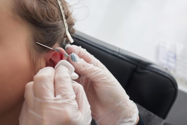 Lobe étiré piercing concept grunge Oreille femme percée avec bouchon noir tunnel industriel et tour