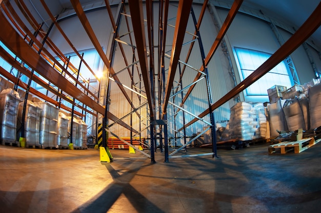 Locaux d'entrepôt d'une usine ou d'un atelier avec étagères métalliques.