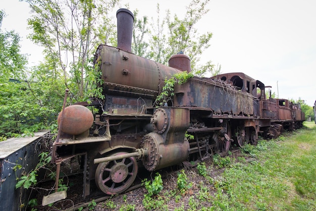 Locomotive à vapeur ancienne et rouillée abandonnée dans une gare perdue