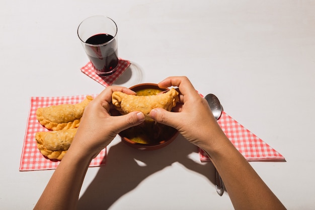 Locro et empanadas de cuisine argentine typique sur fond blanc.