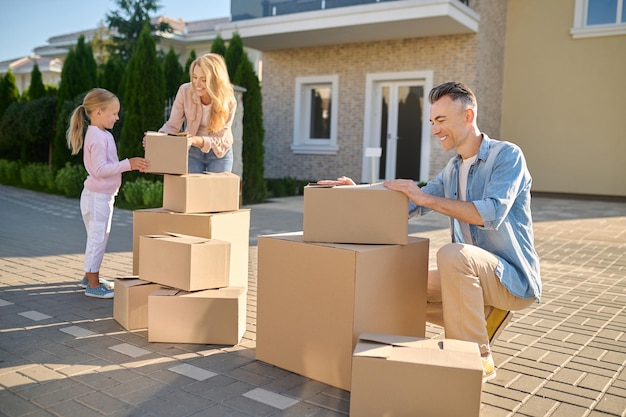 Logement Neuf. Famille Déménageant Dans Une Nouvelle Maison Et Transportant Des Boîtes En Carton