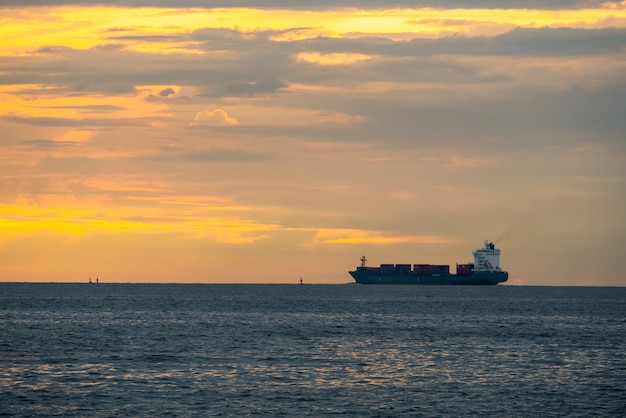 Photo logistique import export conteneur cargo cargo dans le port maritime sur ciel coucher de soleil, transport de fret par bateau porte-conteneurs