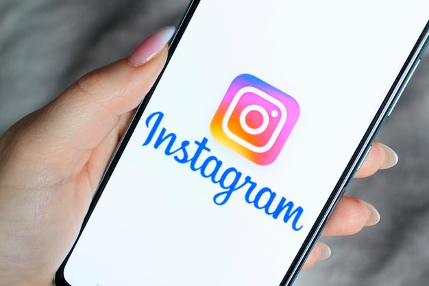 Le logo Instagram sur l'écran du smartphone est entre les mains des femmes Le concept d'utilisation des réseaux sociaux 13 mars 2022 Moguilev Bélarus