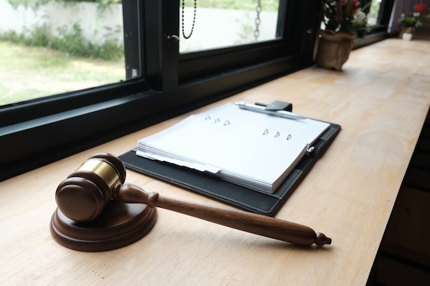 Loi juridique marteau et cahier sur table en bois.