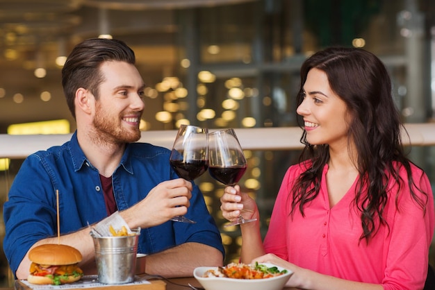 loisir, fête, nourriture et boissons, concept de personnes et de vacances - couple souriant en train de dîner et de boire du vin rouge à la date du restaurant