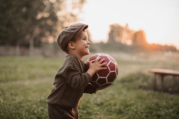 Loisirs actifs Un garçon joue au football à l'extérieur à la campagne
