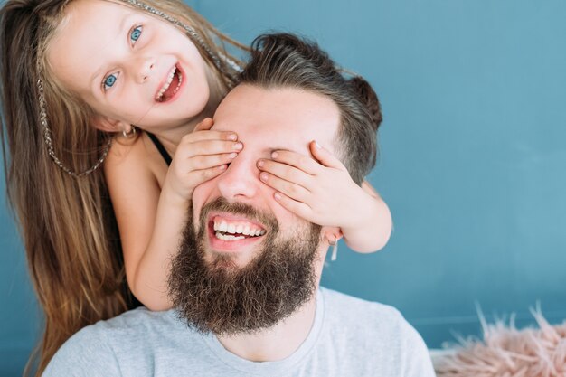 Loisirs ludiques en famille. expression d'amour de la fille. petite fille couvrant les yeux de papa par derrière