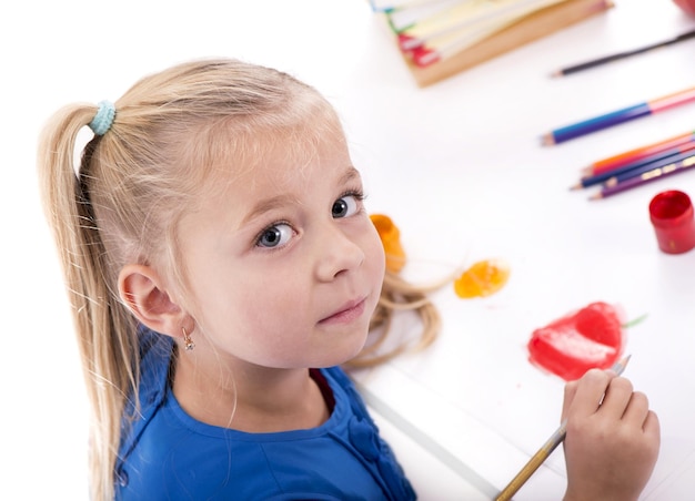 Loisirs pour enfants créativité une petite fille en robe bleue dessine des peintures