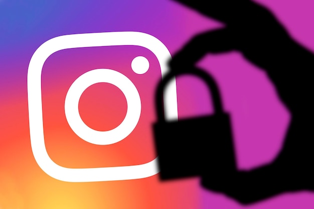 Photo london uk 5 février 2018 concept de sécurité instagram silhouette d'une main tenant un cadenas devant le logo instagram