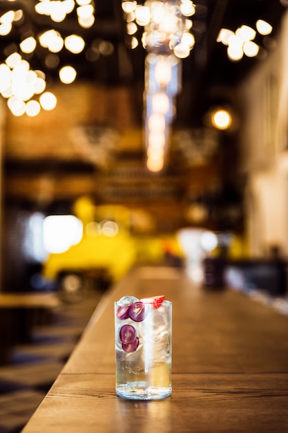 Un long drink glacé rafraîchissant avec des raisins et des fraises au bar