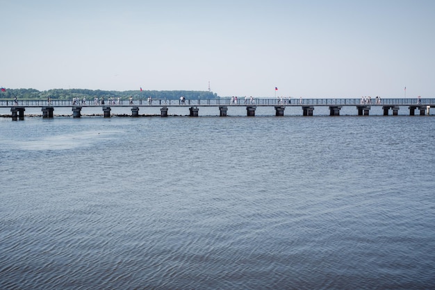 Un long pont dans la mer de la jetée au rivage du golfe de Finlande