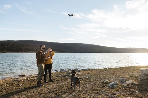 Photo long shot couple avec chien à l'extérieur