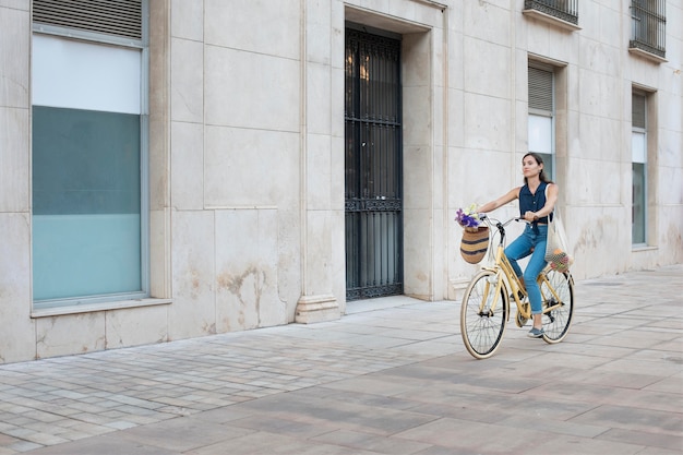 Long shot femme à vélo