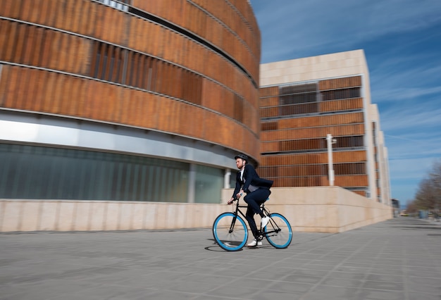 Long shot jeune homme va travailler à vélo