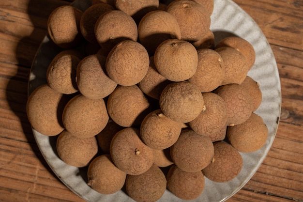 Longane séché dans le conteneur sur la table à grain de bois