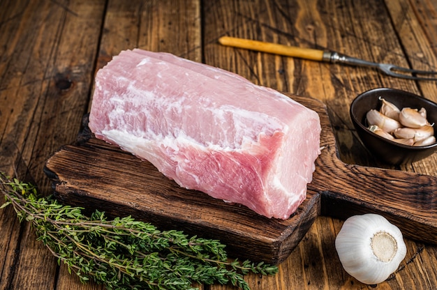 Longe de porc crue aux épices sur planche de bois