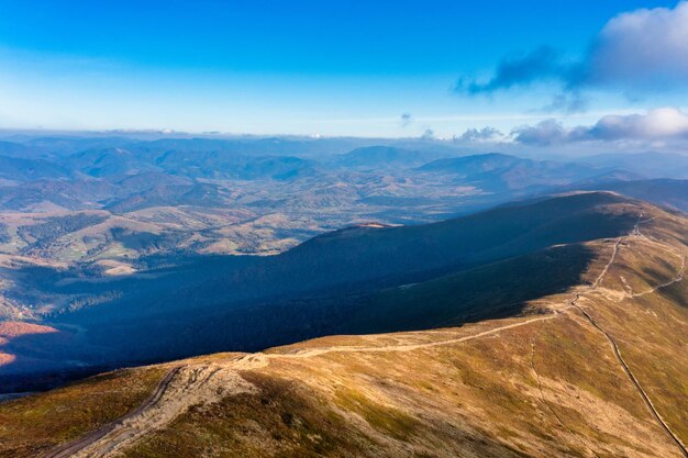 De longs sentiers longeant les montagnes sous le ciel bleu