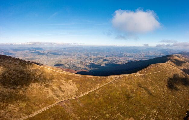 De longs sentiers longeant les montagnes sous le ciel bleu