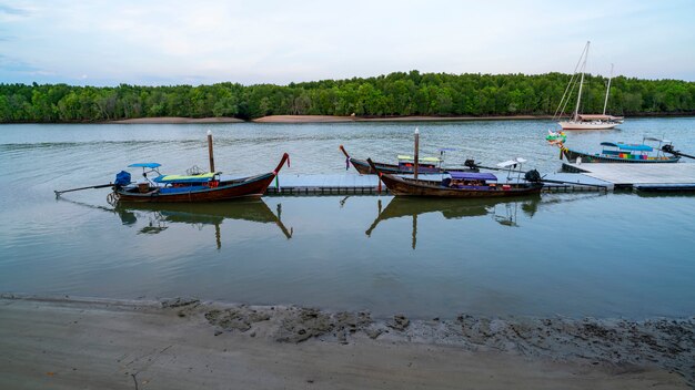 Longtail boat avec reflex dans la mer Beau lever de soleil sur la mer et la forêt de mangrove à phang