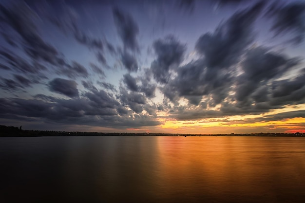 Longue exposition coucher de soleil sur le lac Nuages flous et eau