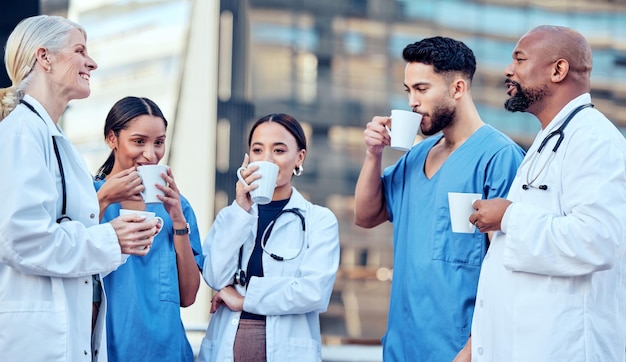 De longues heures de travail nécessitent de bonnes tasses de café Photo d'un groupe de médecins buvant du café dans la ville