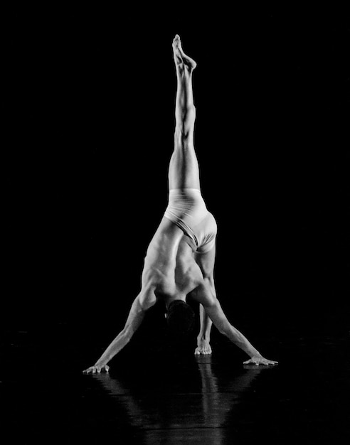 La longueur complète d'une danseuse sans chemise sur un fond noir