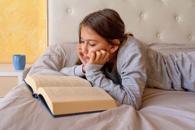 La longueur complète de la femme allongée sur le lit à la maison