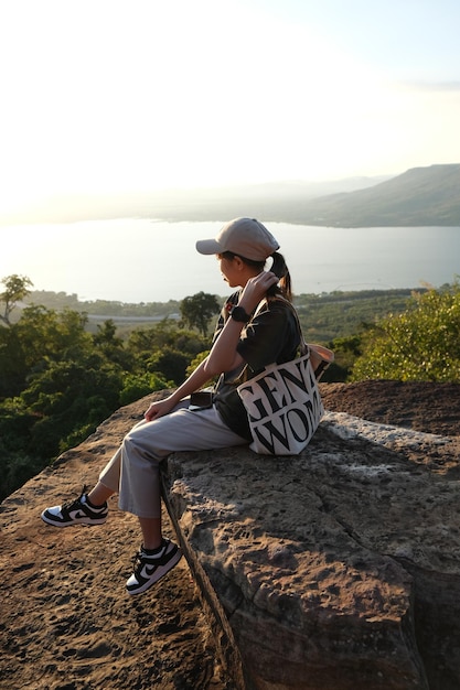 Photo longueur complète d'une femme debout sur la montagne contre le ciel au coucher du soleil