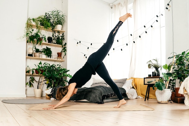 Longueur complète de la femme faisant de l'exercice à la maison