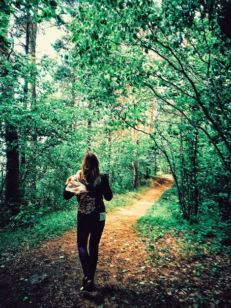 Longueur complète d'une femme marchant sur un sentier dans la forêt