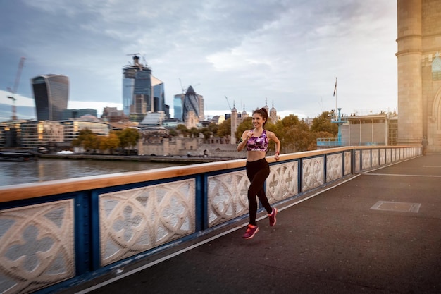 Photo longueur complète de la femme sur le pont contre les bâtiments de la ville