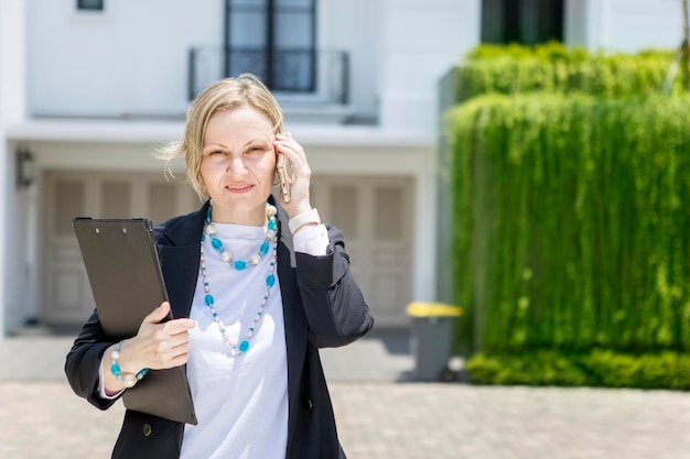 Photo la longueur complète d'une femme tenant un smartphone alors qu'elle se tient à l'extérieur