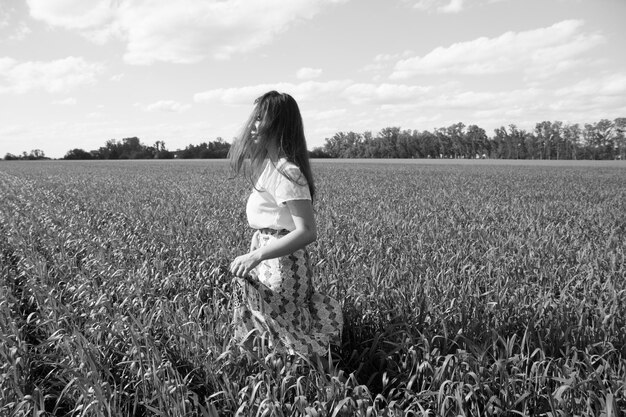 Longueur complète de la femme sur le terrain contre le ciel