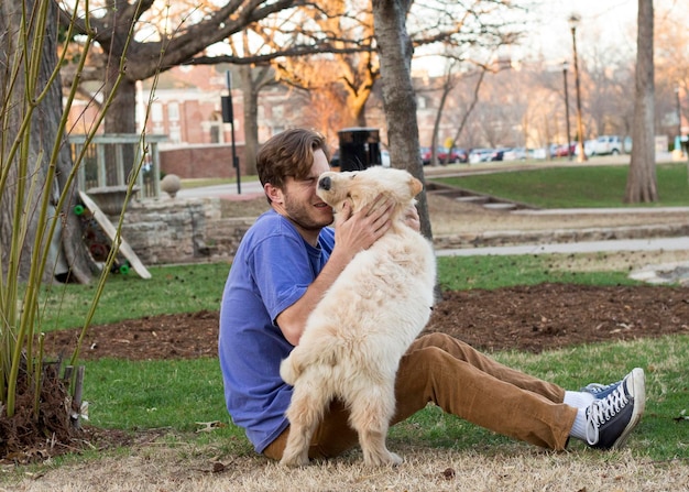 Longueur complète de l'homme assis avec le chien