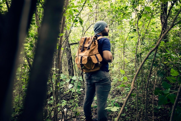 Longueur complète d'un homme marchant dans la forêt