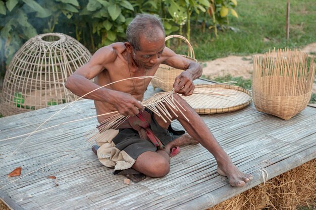 Photo longueur complète d'homme sans chemise assis dans un panier en osier